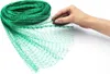A hand is holding a piece of green netting that is unrolled from a larger roll. Produktbild-Vorschau
