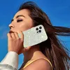 A woman holding a sparkly phone case to her ear against a blue sky. Produktbild-Vorschau