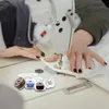 A person is using a sewing machine, with spools of thread in the foreground. Produktbild-Vorschau