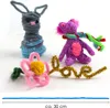 Crafted pipe cleaner figures and decorations on a white background. Produktbild-Vorschau