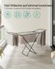 A SONGMICS foldable drying rack with laundry on it, placed on a balcony or patio. Produktbild-Vorschau