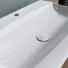 A close-up view of a white ceramic sink with a drain. Produktbild-Vorschau