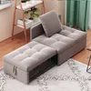 A grey sofa bed is shown in a room with wooden flooring and a rug.
