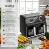 A black dual-chamber air fryer is shown in a kitchen setting with food items like corn on the cob and onion rings. Produktbild-Vorschau