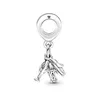 A silver charm with a loop at the top and a dangling charm featuring a plane, globe, and suitcase. Podgląd zdjęcia produktu