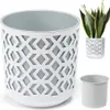 A white planter with a geometric cut-out pattern and a grey inner pot, shown with a smaller planter containing a snake plant and a separate inner pot. Podgląd zdjęcia produktu