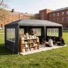 A dark gray canopy tent set up on a grassy lawn in front of brick buildings, with a bookshelf filled with books inside and people reading. Voir les images du produit