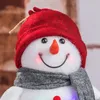 Close-up of a decorative snowman figurine with a red hat and gray scarf. Produktbild-Vorschau