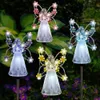 Four solar-powered angel garden lights are displayed in a garden setting with flowers and foliage. Náhľad obrázku produktu