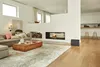 A modern living room with a fireplace, sofa, and coffee table. Náhled obrázku produktu