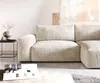 A modern living room scene featuring a beige sectional sofa. Produktbild-Vorschau
