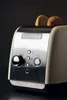 A close-up shot of a cream and silver KitchenAid toaster with two slices of toast visible in the slots. Anteprima dell’immagine prodotto