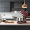 A red stand mixer is shown on a kitchen counter, with a sink and cabinets in the background. Anteprima dell’immagine prodotto