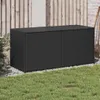 A black poly rattan garden storage box sits on gravel in front of a wooden fence and a brick wall. Náhled obrázku produktu