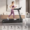 A woman is running on a treadmill in a modern living room. Produktbild-Vorschau