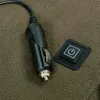 A close-up view of a car charger plug and a power button with a power symbol, resting on a textured brown surface. Náhľad obrázku produktu
