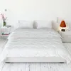 A neatly made bed with white bedding in a minimalist bedroom setting. Produktbild-Vorschau