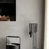 A fireplace set and log basket are shown next to a fireplace with logs inside. Anteprima dell’immagine prodotto