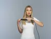 A woman is straightening her hair with a flat iron. Náhľad obrázku produktu