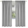 Two light gray curtains hanging on a curtain rod in front of a window with greenery visible outside.