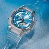 A close-up shot of a transparent G-Shock watch with a blue face, set against a textured blue background. Anteprima dell’immagine prodotto