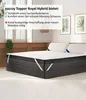 A mattress topper is shown on a bed in a bedroom setting, with text overlays highlighting its features. Produktbild-Vorschau