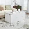 A white coffee table with storage is placed in a living room setting next to a beige sofa. Podgląd zdjęcia produktu