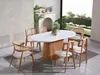 A dining table and chairs set in a well-lit room with a fireplace and large window. Produktbild-Vorschau