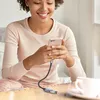 A woman is using her smartphone while it is connected to an adapter cable. Náhľad obrázku produktu