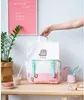 A Pusheen backpack is displayed on a wooden desk with various decorative items. Anteprima dell’immagine prodotto
