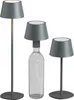 Three modern LED table lamps of varying heights, one of which is placed on a clear glass bottle. Produktbild-Vorschau