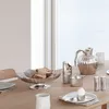 A table setting with various silver serving dishes and utensils, including a bread bowl, a pitcher, salt and pepper shakers, and an egg cup with an egg. Anteprima dell’immagine prodotto