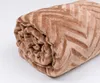 A rolled-up brown blanket with a chevron pattern is shown against a white background. Podgląd zdjęcia produktu