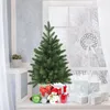 A mini Christmas tree with gifts and decorations on a windowsill with a snowy view outside. Produktbild-Vorschau