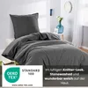 A bed with dark gray bedding, including a duvet and pillow, in a bedroom setting. Decorative elements like a vase with flowers and a framed picture are visible in the background. Náhled obrázku produktu