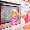 A person is cleaning an oven with a spray bottle. Produktbild-Vorschau