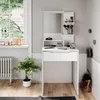 A white vanity table with a mirror and makeup accessories is set up in a room with a window and a radiator. Produktbild-Vorschau