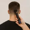 A person is using an electric hair clipper to trim the back of their head. Náhled obrázku produktu