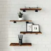 Four wooden shelves mounted on a white brick wall, decorated with books, a plant, framed pictures, and a pencil holder. Anteprima dell’immagine prodotto