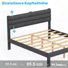 A close-up view of a dark gray upholstered bed frame with a slatted wooden base. Arrows indicate adjustable headboard height. Produktbild-Vorschau
