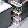 A hand is shown reaching for a white rolling storage cart filled with various bottles and cans, placed next to a kitchen counter. Náhled obrázku produktu
