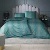 A bedroom scene with a bed dressed in teal and gold patterned bedding. Produktbild-Vorschau