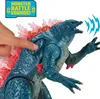 A hand is pressing a button on a Godzilla toy, which is emitting sound waves. Produktbild-Vorschau