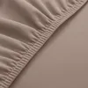 A close-up of a beige fabric with elastic gathering, likely a part of a chair cover. Náhľad obrázku produktu