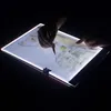 Hands using a light pad to trace a drawing in a dark room. Náhled obrázku produktu