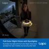A woman is holding a cake in front of a door at night, with a security camera view overlay. Produktbild-Vorschau