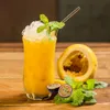 A glass of passion fruit puree with crushed ice and mint, next to passion fruits and mint leaves on a wooden table. Podgląd zdjęcia produktu