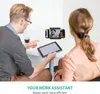 Two people are sitting at a table, looking at a tablet and a smartphone. The smartphone is mounted on a stand. Voir les images du produit