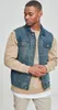 A man wearing a denim vest over a tan sweatshirt. Produktbild-Vorschau