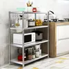 A stainless steel shelving unit filled with kitchen appliances and utensils, placed in a kitchen setting next to a stove. Voir les images du produit